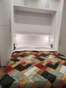 - un lit avec une couverture multicolore dans l'établissement La casa di Bibi, à Gênes