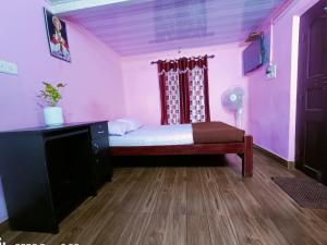a bedroom with a bed and a dresser in a room at CAFFEE ISLAND FARM VILLA in Kaniyāmbetta
