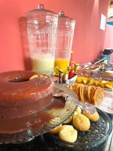 a table topped with a chocolate cake and a plate of food at Hospedaria Mucugê - na principal rua da cidade, Rua do Mucugê - Arraial d'Ajuda in Arraial d'Ajuda +50 photos