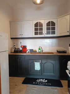 a kitchen with black and white cabinets and a kitchen rug at Pablo Boutique Rooms in Néon Petrítsion