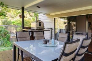 a table and chairs on a patio with a kitchen at kin kin cottage, Noosa hinterland, walk to town. in Kin Kin