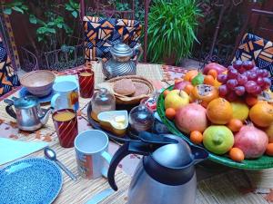 stół z talerzem owoców i dzbanem w obiekcie Ryad Nour Al Janoub w Marakeszu