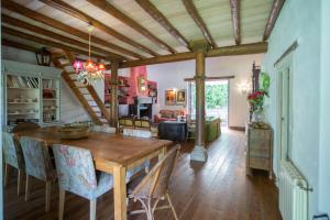 a dining room and living room with a wooden table at Cortijo Chacón in Cazalla de la Sierra