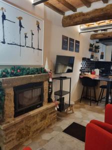 a living room with a fireplace and a table at OgniVolta in Pienza