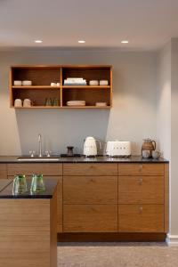 a kitchen with wooden cabinets and a counter at Hypernym Hotel & Suites in Copenhagen