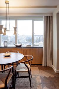 a dining room with a table and chairs and a large window at Hypernym Hotel & Suites in Copenhagen
