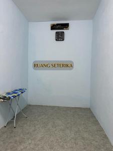 a white room with a clock on the wall at ALUNAN HOMESTAY in Kangar