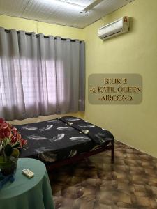 a bedroom with a bed in a room with a window at ALUNAN HOMESTAY in Kangar