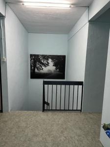a room with a white wall with a picture on it at ALUNAN HOMESTAY in Kangar