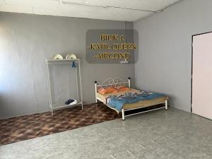 a bedroom with a bed and a sign on the wall at ALUNAN HOMESTAY in Kangar