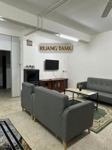 a living room with two couches and a tv at ALUNAN HOMESTAY in Kangar