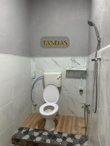 a bathroom with a toilet and a sign that reads tamales at ALUNAN HOMESTAY in Kangar