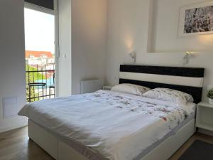 um quarto branco com uma cama grande e uma varanda em Meldolla em Zagreb