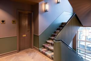a staircase in a home with a blue wall at Hypernym Hotel & Suites in Copenhagen