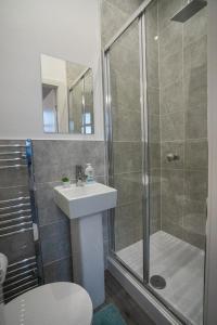 a bathroom with a shower and a sink and a toilet at Isimi luxurious 4 bed 4 en -suite house Cumbria in Barrow in Furness