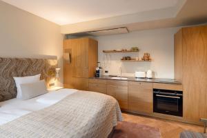 a hotel room with a bed and a kitchen at Hypernym Hotel & Suites in Copenhagen
