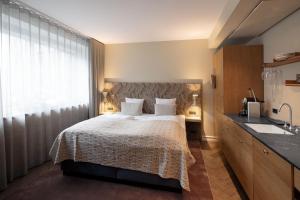 a bedroom with a bed and a sink at Hypernym Hotel & Suites in Copenhagen