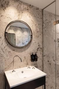 a bathroom with a sink and a mirror at Hypernym Hotel & Suites in Copenhagen