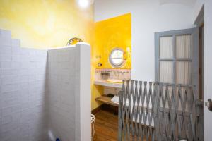 a bathroom with yellow walls and a sink and a mirror at Cortijo Chacón in Cazalla de la Sierra +12 photos