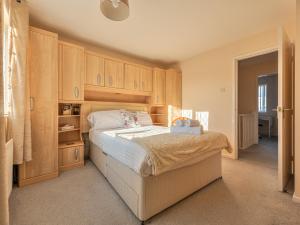 1 dormitorio con 1 cama grande y armarios de madera en Lovely Detached Home Pass The Keys, en Telford