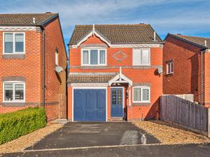 an orange brick house with a blue garage at Lovely Detached Home Pass The Keys in Telford