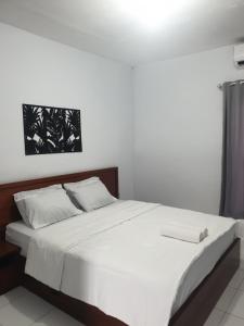 a bed with white sheets and pillows in a bedroom at BTN Mahkota Pemenang 13 Tamarin 3A in Pawenang