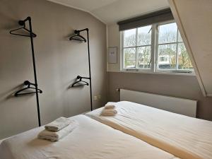 een slaapkamer met een bed met twee handdoeken erop bij Appartement Zilt DO47 Domburg in Domburg