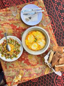 una mesa con platos de comida en una mesa en Mhamid yaya camp, en Mhamid