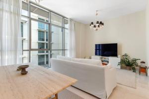 a living room with a white couch and a table at LARBI Luxurious 1BR in Polo Residence in Dubai