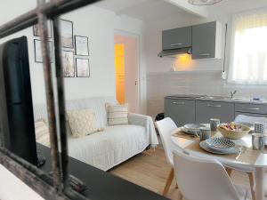 een keuken en een woonkamer met een tafel bij Le Côtier in Blériot-Plage