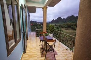 a balcony with a table and chairs and a view at Phong Nha Cherish House in Phong Nha