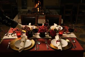 einen Tisch mit Tellern und Gläsern Wein darauf in der Unterkunft Le Cedrus Hotel in Al Arz