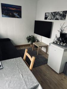 uma sala de estar com uma televisão de ecrã plano e uma mesa em Lovely 1-Bed Apartment in Koblenz em Koblenz