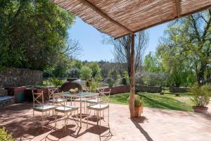 a patio with a table and chairs under a pergola at Cortijo Chacón in Cazalla de la Sierra