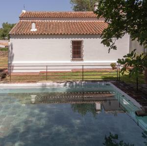 a house and a swimming pool in front of a building at Cortijo Chacón in Cazalla de la Sierra