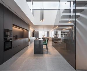 una cucina con armadi neri e una sedia verde di Espectacular casa de lujo y diseño- Sevillarooms a Siviglia
