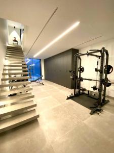 ein Zimmer mit einem Fitnessraum mit einem Laufband und einer Treppe in der Unterkunft Espectacular casa de lujo y diseño- Sevillarooms in Sevilla