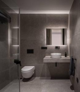 ein Badezimmer mit einem WC, einem Waschbecken und einem Spiegel in der Unterkunft Espectacular casa de lujo y diseño- Sevillarooms in Sevilla