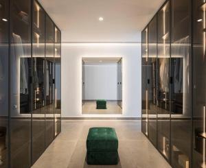 ein Ankleidezimmer mit einer grünen Ottomane in der Mitte in der Unterkunft Espectacular casa de lujo y diseño- Sevillarooms in Sevilla