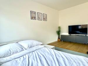 a bedroom with a bed and a flat screen tv at Luxuriös - Dachterrasse - Küche in Forchheim