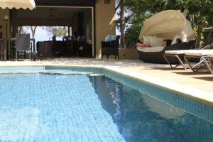 ein Pool mit einem Boot neben einem Haus in der Unterkunft Villa Fayette Sur Mer in Post of Flacq