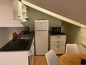 a small kitchen with a refrigerator and a microwave at ATTIC FLOOR in Stockholm City! 918 in Stockholm