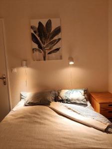 Un dormitorio con una cama y una mesa con una pintura en Bel appartement refait à neuf, calme et ensoleillé, en Cabourg