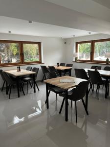 a dining room with tables and chairs and windows at Rozetka Białka in Białka Tatrzańska