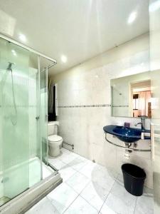 uma casa de banho com uma cabina de duche em vidro e um lavatório azul em Holikeys - Rabat - 1 Ch - Agdal 002 em Rabat