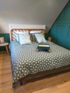 a bedroom with a bed with a wooden headboard at Gite Les Matines in Sebourg
