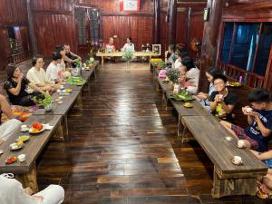 a group of people sitting at long tables in a restaurant at Tâm Viên Homestay Hà Nội in Hanoi