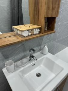 a white sink in a bathroom with a mirror at Exclusive USA Embassy Proximity Apartments in Ulaanbaatar