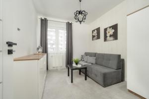 a living room with a couch and a table at Black and White Apartment Close to the River in Wrocław by Renters in Wrocław