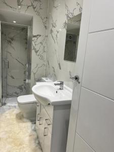 a white bathroom with a sink and a toilet at Amazing 1 Bedroom Flat in Croydon